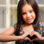 Little girl making a heart